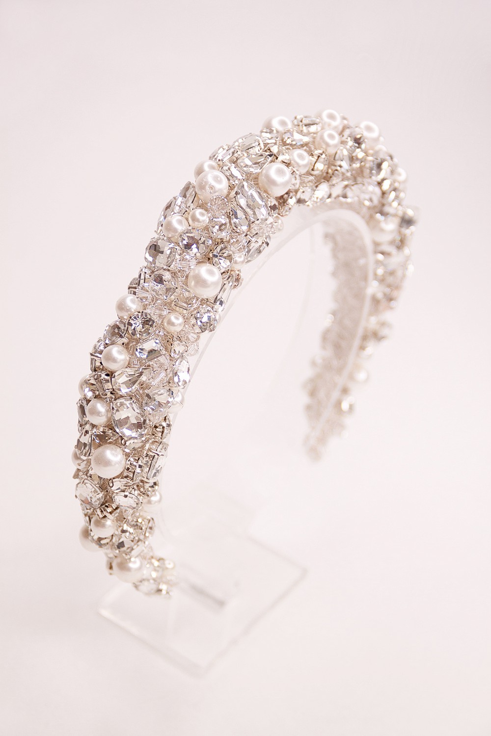 A stunning design encrusted with various shaped sparkling set stones, shimmering crystals and glossy pearl highlights, all combine to make a gloriously glittering textured headpiece.
